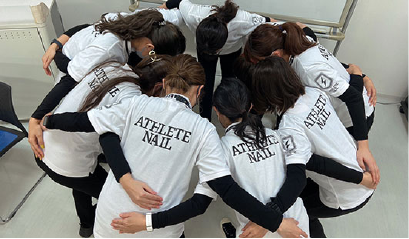 円陣を組むネイルトレーナー